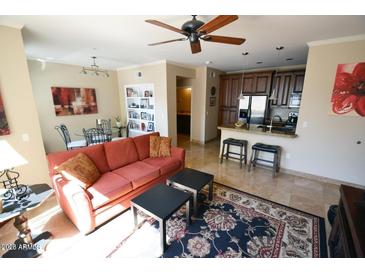 Bright living room featuring a ceiling fan, comfortable seating, and a view of the kitchen at 5345 E Van Buren St # 115, Phoenix, AZ 85008