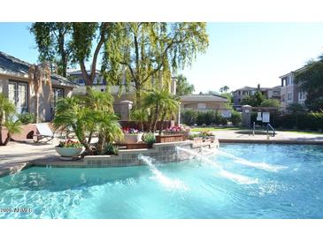 Community pool with waterfalls, lush landscaping and lounge chairs at 5345 E Van Buren St # 116, Phoenix, AZ 85008