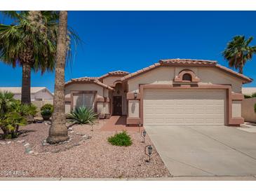 Charming single-story home featuring a two-car garage and mature landscaping at 17585 N Coyote Lakes Pkwy, Surprise, AZ 85378