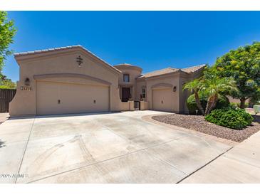 Stunning single-story home with well-manicured landscaping, three-car garage, and inviting curb appeal at 21275 E Russet Rd, Queen Creek, AZ 85142