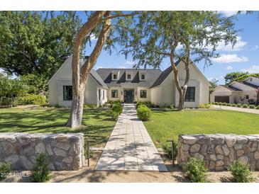 Elegant home exterior featuring lush green lawn, mature shade trees, and a welcoming walkway leading to the entrance at 325 W Solano Dr, Phoenix, AZ 85013