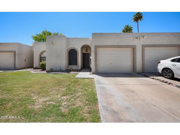 Charming single-story home featuring a well-manicured lawn and attached two-car garage at 9313 W Morrow Dr, Peoria, AZ 85382