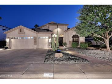 Charming home showcasing a three-car garage, desert landscaping, and inviting front entrance at twilight at 1085 E Oakland Ct, Gilbert, AZ 85295