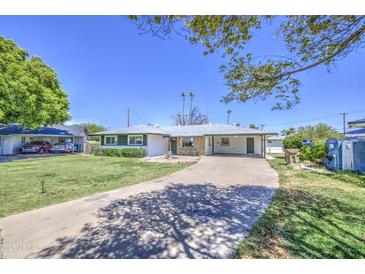 Charming single-story home with a covered carport and a lush green lawn in a desirable neighborhood at 1917 W Ashland Ave, Phoenix, AZ 85009