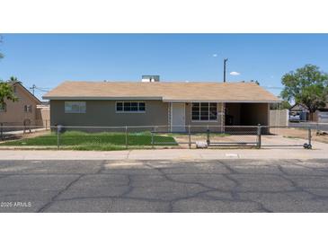 Single story home with neutral siding, brown roof, chain link fence, and covered carport at 3802 W Mulberry Dr, Phoenix, AZ 85019
