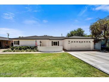 Charming single-story home featuring a well-maintained lawn, white brick, and an attached two-car garage at 4243 E Avalon Dr, Phoenix, AZ 85018