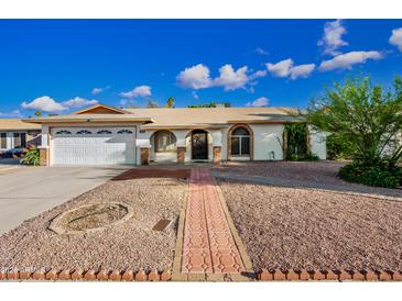 Charming single-story home featuring a well-maintained facade, desert landscaping, and an arched front door at 5803 W John Cabot Rd, Glendale, AZ 85308
