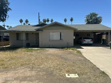 A cozy single-story home with a carport, desert landscaping, and a charming, sun-drenched facade at 61 W 11Th Dr, Mesa, AZ 85210