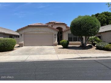 Single-story home with a two-car garage, desert landscaping, and a terracotta tile roof at 6376 W Adobe Dr, Glendale, AZ 85308