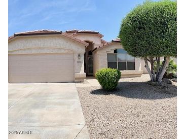Single-story home with a well-maintained front yard and a two-car garage at 6376 W Adobe Dr, Glendale, AZ 85308