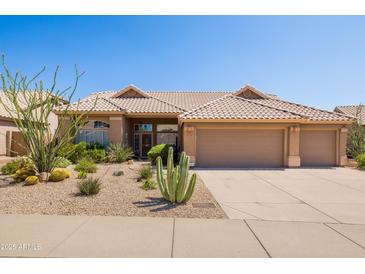 Charming single-story home with a well-manicured desert landscape and a three-car garage at 11103 E Blue Sky Dr, Scottsdale, AZ 85262