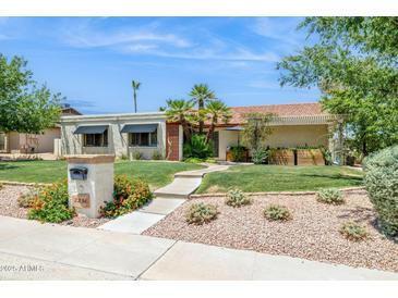 Inviting single-story home with manicured lawn, desert landscaping, and a picturesque walkway at 2236 E Sierra St, Phoenix, AZ 85028