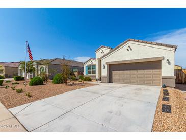 Charming single-story home with a two-car garage, low maintenance landscaping, and a well-lit exterior at 30128 W Weldon Ave, Buckeye, AZ 85396