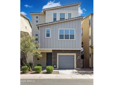 Modern two-story home with neutral siding, brick accents, a gray garage door, and well-maintained landscaping at 663 W Flintlock Way, Chandler, AZ 85286