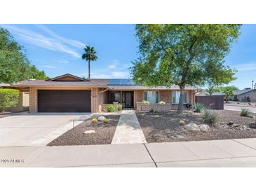 Charming single-story brick home featuring a well-manicured front yard and a welcoming entrance at 10590 E Mercer Ln, Scottsdale, AZ 85259