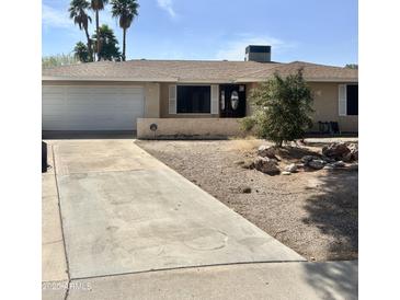 Single-story home with desert landscaping, a driveway, attached garage, and a welcoming front entrance at 1304 E Hackamore St, Mesa, AZ 85203