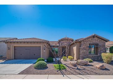 Charming desert home featuring a stone facade, desert landscaping, and a two-car garage at 26333 W Vista North Dr, Buckeye, AZ 85396