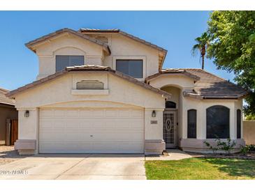 Charming two-story home featuring a well-maintained front yard and attached two-car garage on a sunny day at 2963 S 83Rd St, Mesa, AZ 85212