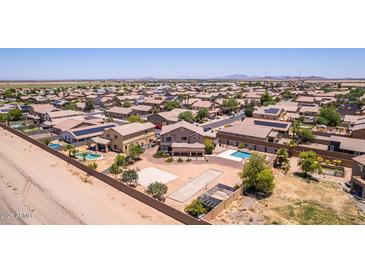 Expansive aerial view of a neighborhood with pools, sport courts and desert landscaping at 36645 W Bilbao St, Maricopa, AZ 85138