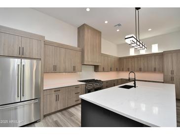 Modern kitchen featuring quartz countertops, stainless steel appliances, and custom wood cabinetry at 8934 E Rusty Spur Pl, Scottsdale, AZ 85255