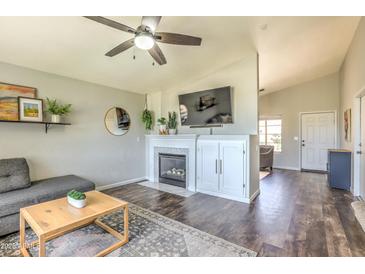 Inviting living room features a fireplace, dark wood floors, ceiling fan, and neutral wall color at 1212 S Boulder St # C, Gilbert, AZ 85296