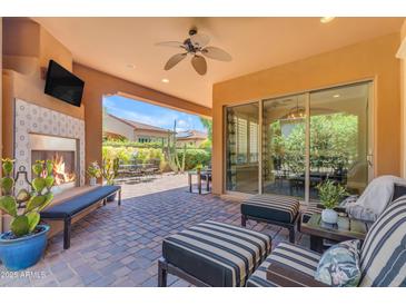Outdoor patio with fireplace, ceiling fan, and comfortable seating, perfect for entertaining at 1771 E Alegria Rd, Queen Creek, AZ 85140
