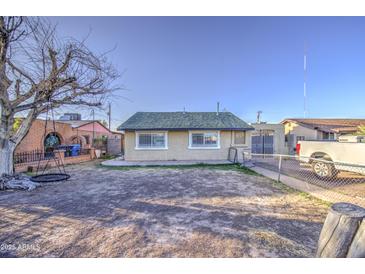 Large backyard featuring a chain-link fence, bare tree, and access to a neighboring property at 2430 W Papago St, Phoenix, AZ 85009