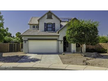 Charming two-story home featuring a large two-car garage and a beautifully landscaped front yard with mature trees at 41581 W Somerset Dr, Maricopa, AZ 85138