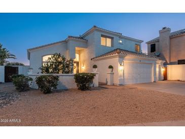 Two-story stucco home with a two-car garage and tile roof, featuring desert landscaping at 13 W Silverwood Dr, Phoenix, AZ 85045