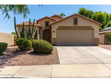 Charming single-story home with a two-car garage, desert landscaping, and a tile roof at 13373 W Boca Raton Rd, Surprise, AZ 85379