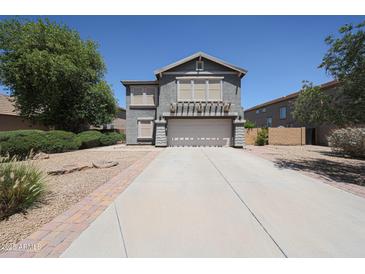 Charming two-story home featuring a well-manicured front yard and inviting curb appeal at 14770 W Columbine Dr, Surprise, AZ 85379
