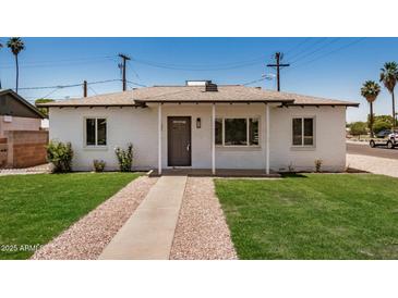 Charming single-story home with a well-manicured lawn and inviting front entrance at 162 N Hunt W Dr, Mesa, AZ 85203