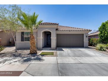 Charming single-story home featuring a low-maintenance front yard, desert landscaping, and a two-car garage at 2704 S 172Nd Ln, Goodyear, AZ 85338