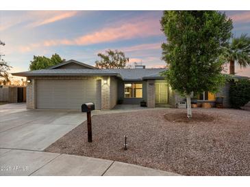 Charming single-story home with brick accents, a two-car garage, and desert landscaping at 2726 W Meseto Cir, Mesa, AZ 85202