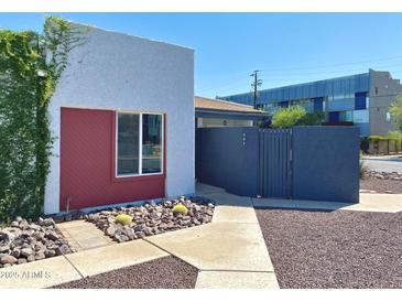 Charming home featuring unique architectural details, modern gray stucco, and a vibrant red accent wall at 3551 N 12Th St # 101, Phoenix, AZ 85014