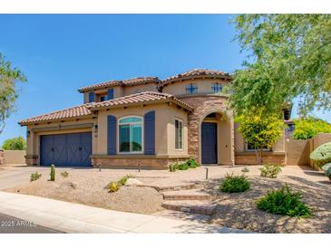 Beautiful two-story home showcasing a blue garage door, tile roof, and desert landscaping at 3804 E Daley Ln, Phoenix, AZ 85050