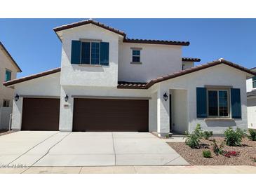 Inviting two-story home featuring a three-car garage, desert landscaping, and a charming architectural design at 4930 W Brown St, Glendale, AZ 85302