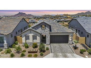 Charming single-Gathering home featuring stone accents, a two-car garage, and professionally landscaped front yard at 5724 E Scarlet St, Mesa, AZ 85215