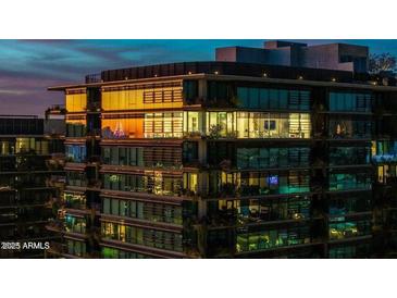 Modern condo building at twilight showcases a sleek design with expansive windows and balconies at 7180 E Kierland Blvd # 1116, Scottsdale, AZ 85254
