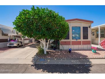 Cozy home featuring charming landscaping and a convenient golf cart parked in the driveway at 8700 E University Dr # 1205, Mesa, AZ 85207