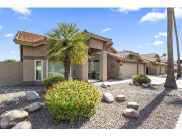 Charming home with a well-maintained front yard and a decorative desert landscape at 1449 W Sherri Dr, Gilbert, AZ 85233