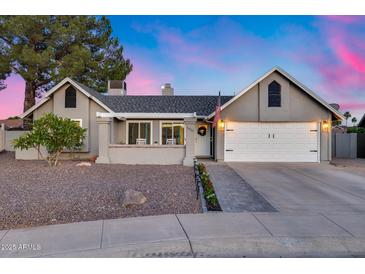 Charming single-story home with a two-car garage, complemented by professional landscaping and a brick entryway at 16437 N 61St Ave, Glendale, AZ 85306