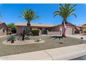 Charming single-story home with desert landscaping, palm trees, and an American flag at 1753 Leisure World --, Mesa, AZ 85206