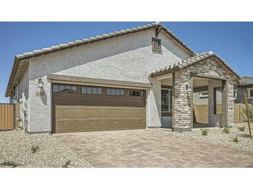 Charming single-Gathering home featuring stucco siding, brick accents, and a large two car garage at 25188 N 174Th Ave, Surprise, AZ 85387