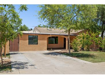 Charming single-story home with a covered porch, mature trees, and a driveway at 2636 N Dayton St, Phoenix, AZ 85006