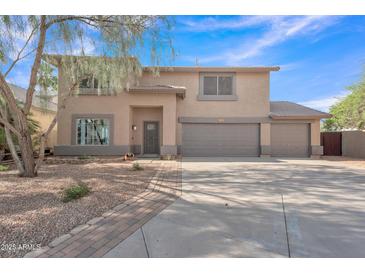 Two-story home featuring a spacious three car garage, desert landscaping, and neutral color palette at 308 E Sheffield Ct, Gilbert, AZ 85296