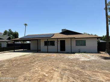 Charming single-story home featuring a covered carport, solar panels, and a freshly landscaped front yard at 4425 W Sierra St, Glendale, AZ 85304