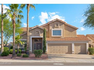 Charming two-story home with three-car garage, desert landscaping, and palm trees under a bright blue sky at 4563 E Libby St, Phoenix, AZ 85032