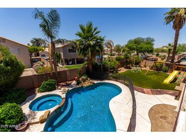 Inviting backyard pool and spa with mature landscaping and a fun playground for endless outdoor enjoyment at 735 W Kelton Ln, Phoenix, AZ 85023