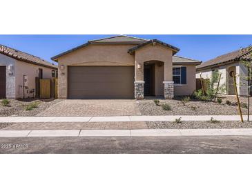 Charming single-story home featuring a paved driveway, neutral stucco, and a covered entryway at 15600 W Williams St, Goodyear, AZ 85338